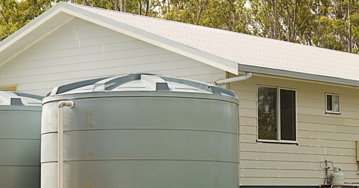 A house with two rainwater tanks being used to supply clean drinking and shower water.
