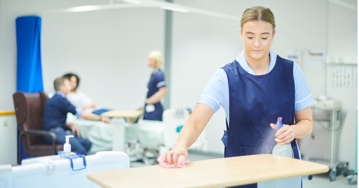 Healthcare worker cleaning a high-touch surface with a hospital grade disinfectant natural vs chemical cleaners