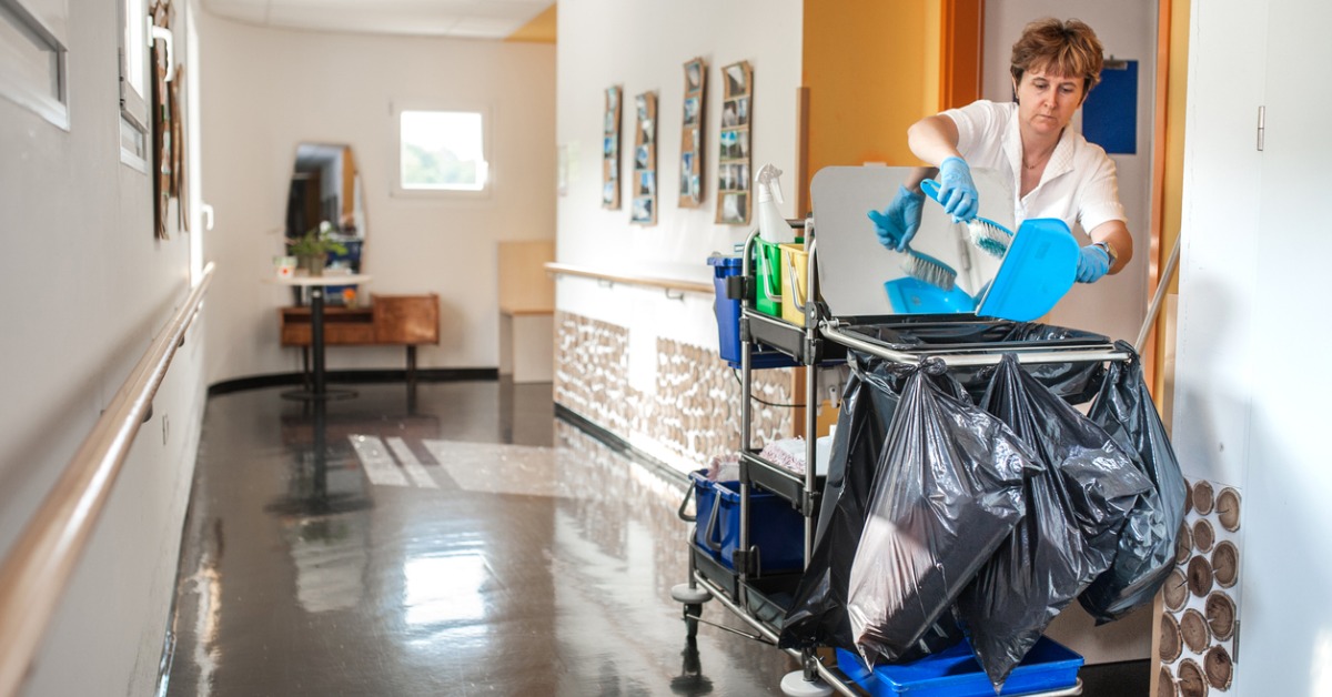 Cleaner using a trolley for cleaning products while cleaning in aged care facilities as part of her job.