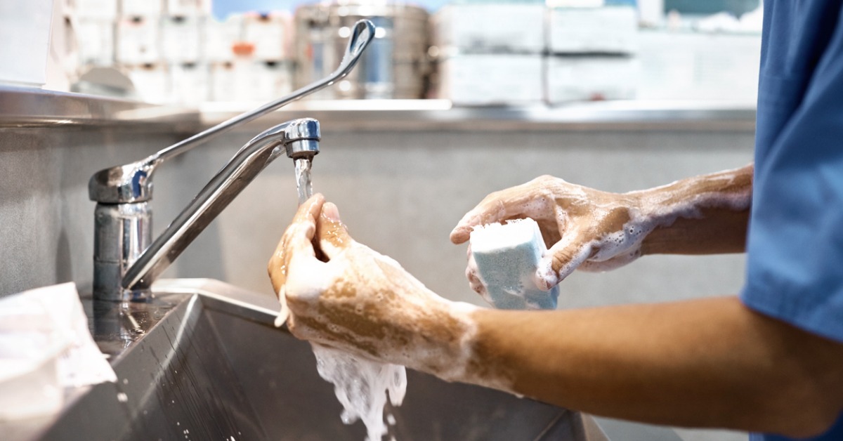 Veterinarian disinfecting surfaces and cleaning hands as part of procedures related to infection control in veterinary practice.