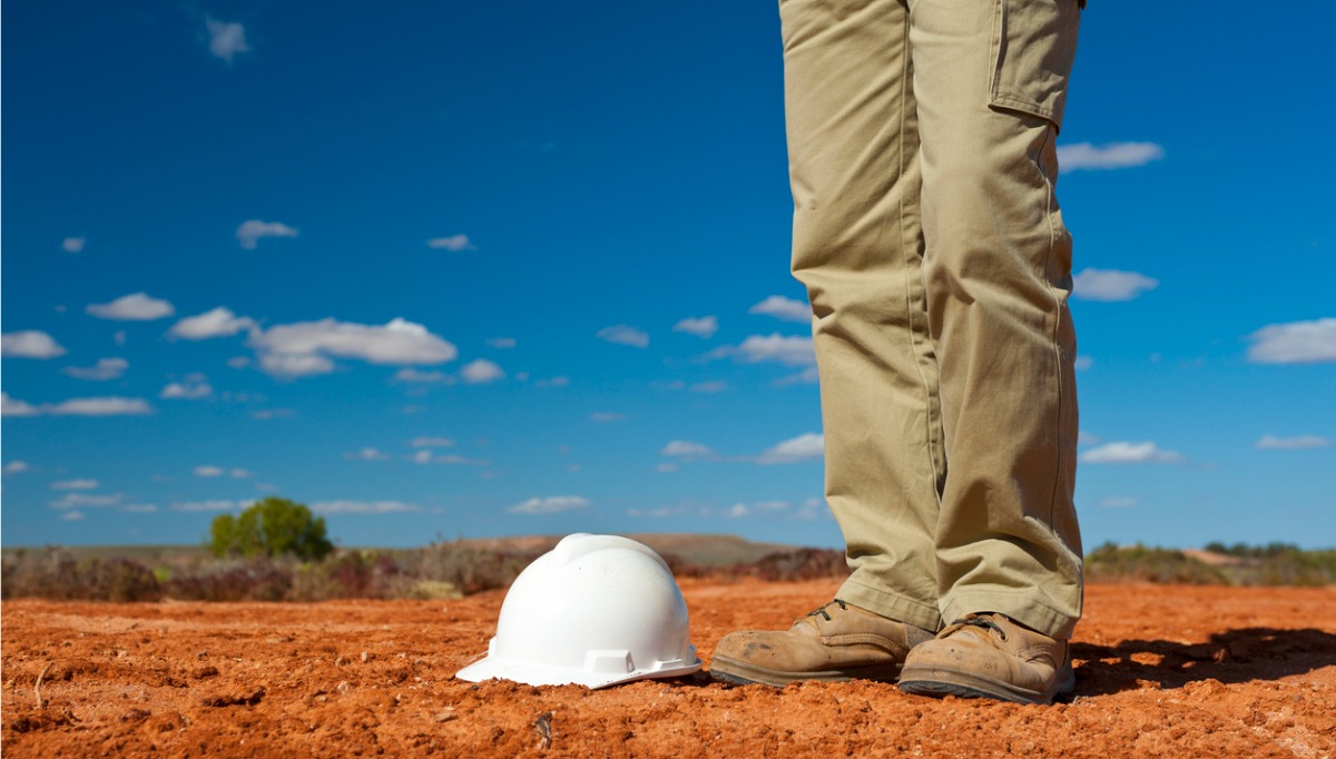 worker standing in a mining site surrounded by dust