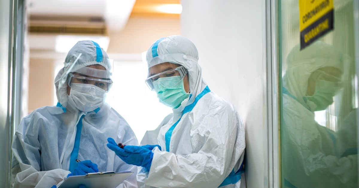 Two healthcare workers dressed in PPE to protect themselves from a potential Biohazard